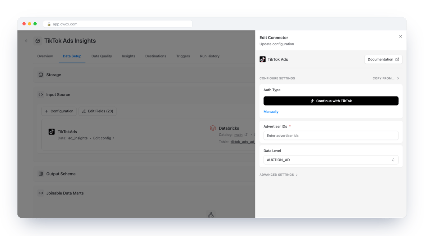 Edit Connector form for TikTok Ads in OWOX Data Marts on a Databricks Data Mart, with a Continue with TikTok button, a Manually link, a required Advertiser IDs field and a Data Level selector set to AUCTION_AD – the grain is chosen in the same form as the sign-in
