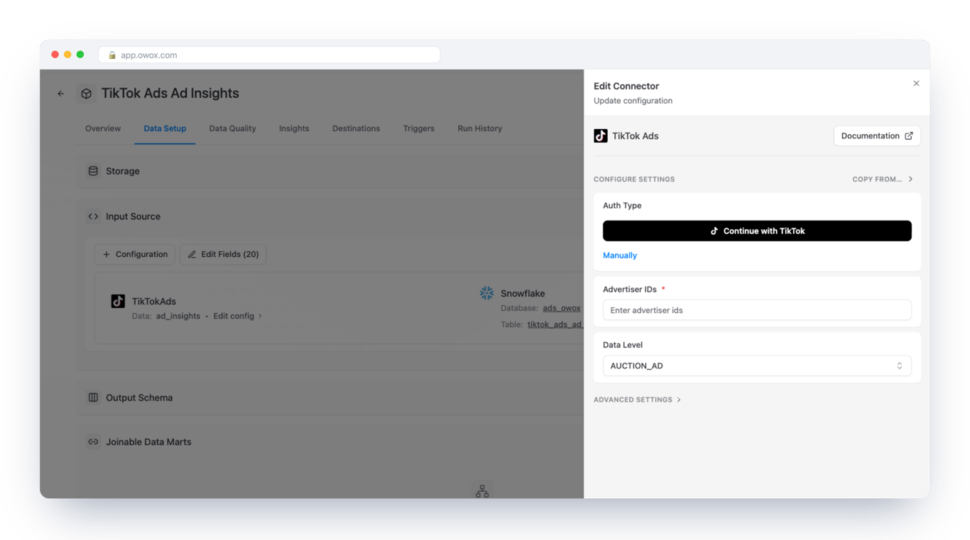 Edit Connector form for TikTok Ads in OWOX Data Marts on a Snowflake Data Mart, with a Continue with TikTok button, a Manually link, a required Advertiser IDs field and a Data Level selector set to AUCTION_AD – the grain is chosen in the same form as the sign-in
